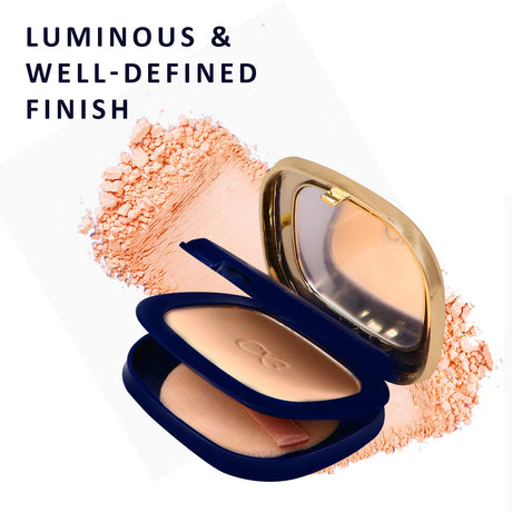 Compact powder with a blue case and gold lid, surrounded by pink powder on a white background.