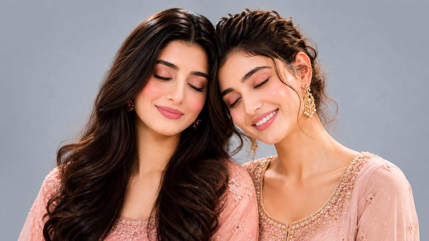 Two women in traditional attire with a plain background