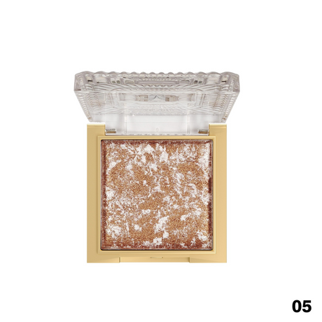 Makeup product with gold and white texture on a clear lid against a white background