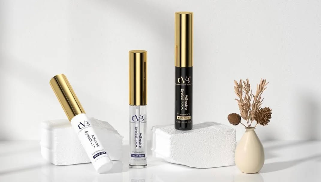 Cosmetic products with gold and black accents on a white surface.