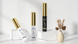 Cosmetic products with gold and black accents on a white surface.
