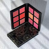 Makeup palette with colorful shades on a white textured surface
