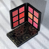 Makeup palette with colorful shades on a white textured surface