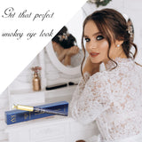 Woman with styled hair and makeup sitting in front of a mirror with makeup products.