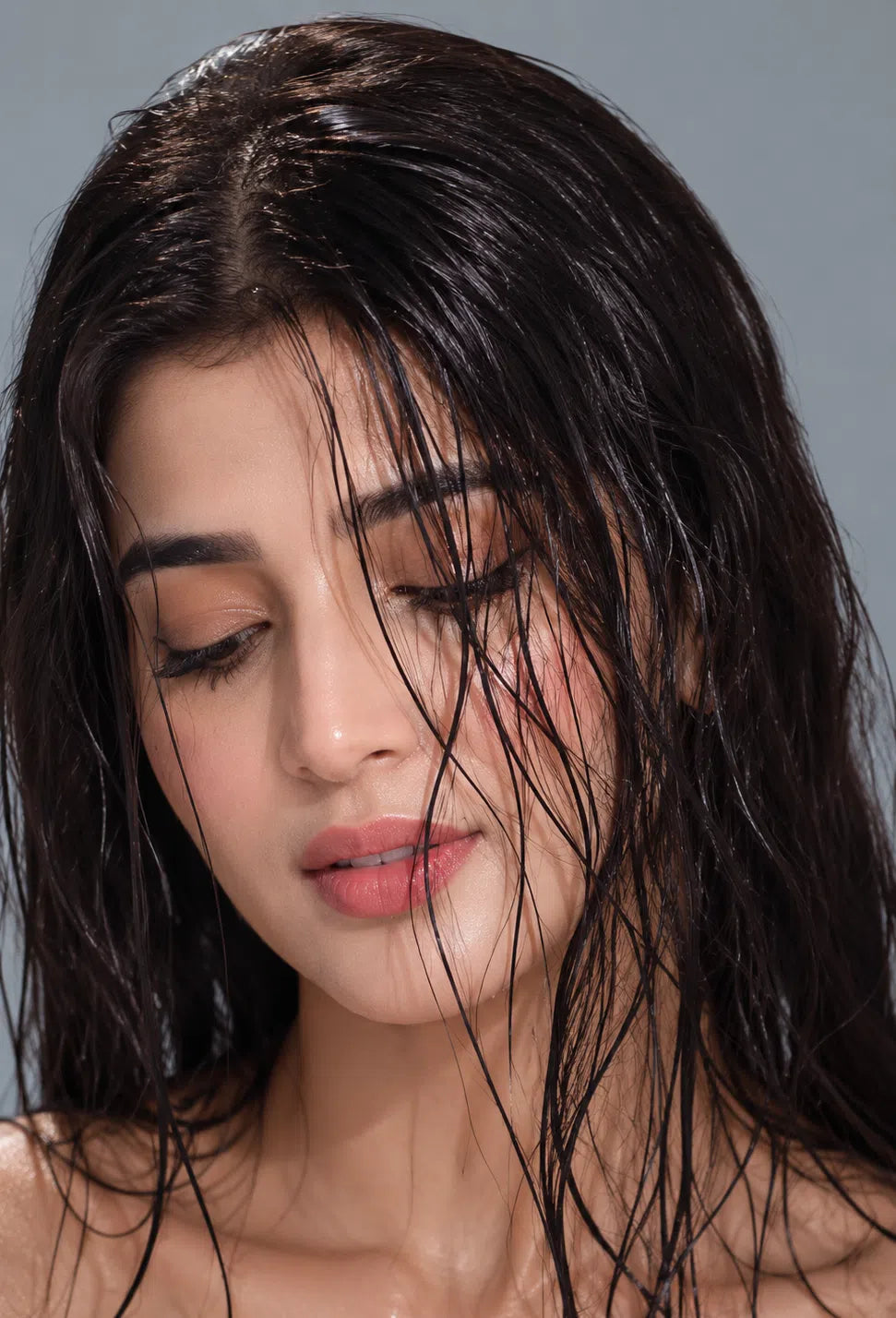 Woman with wet hair against a gray background