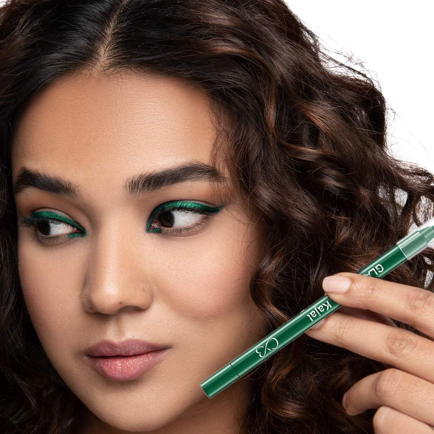 Woman with green eye makeup holding a green eyeliner pencil.