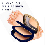 Compact powder with a blue case and gold lid, surrounded by pink powder on a white background.