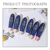 Set of cosmetic sticks with visible brand name on a textured surface