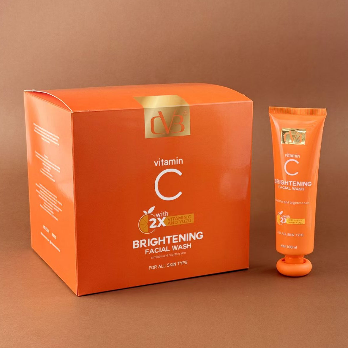 Orange facial wash packaging with a tube on a brown background