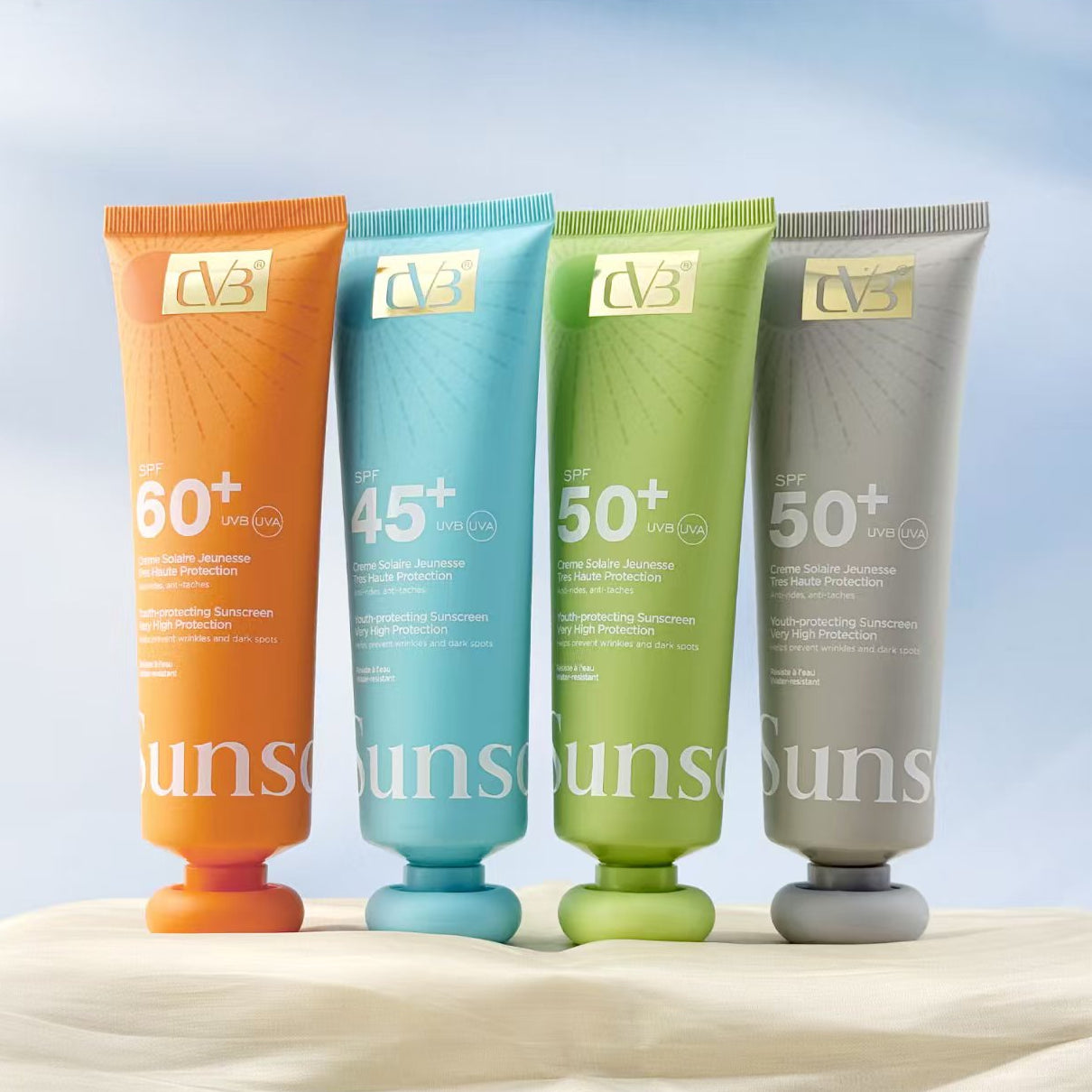 Four sunscreen tubes with different SPF ratings on a sandy background
