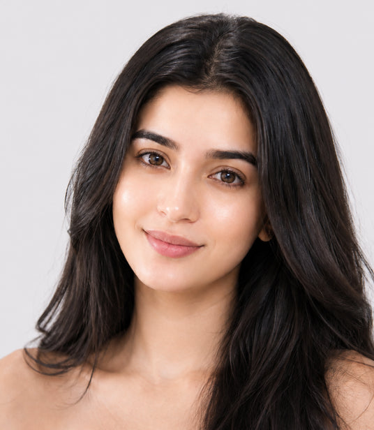 Woman with long dark hair against a plain background