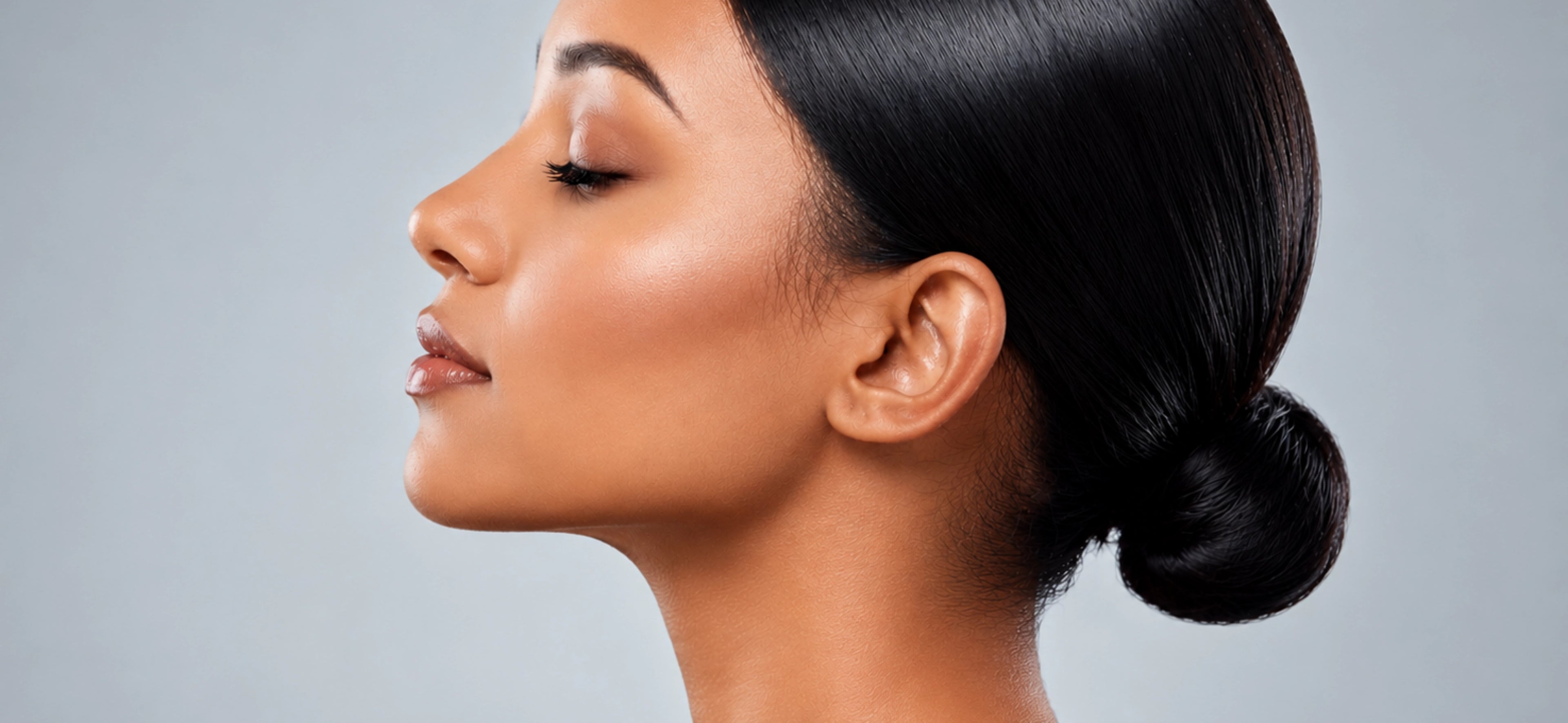 Woman with styled hair against a gray background